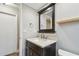 Bathroom featuring a dark vanity with a stone countertop, framed mirror, and open doorway at 1175 San Carlos Ne Ave, St Petersburg, FL 33702