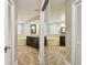 Mirrored bathroom features wood flooring, a double vanity, a soaking tub, and modern finishes at 1175 San Carlos Ne Ave, St Petersburg, FL 33702