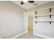 This small bedroom includes built-in shelving and wood flooring, accentuated by fresh neutral paint and a modern ceiling fan at 1175 San Carlos Ne Ave, St Petersburg, FL 33702