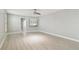 Bright bedroom with wood flooring and fresh neutral paint, featuring a ceiling fan and natural light from a large window at 1175 San Carlos Ne Ave, St Petersburg, FL 33702