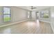 Bright bedroom features wood flooring, fresh neutral paint, a ceiling fan, and natural light from multiple windows at 1175 San Carlos Ne Ave, St Petersburg, FL 33702