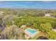 Aerial view of a community pool and clubhouse surrounded by lush greenery at 1175 San Carlos Ne Ave, St Petersburg, FL 33702