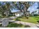 Charming single-story home featuring a well-manicured lawn and mature trees at 1175 San Carlos Ne Ave, St Petersburg, FL 33702