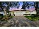 Charming single-story home featuring a well-manicured lawn, mature trees, and an attached two-car garage at 1175 San Carlos Ne Ave, St Petersburg, FL 33702