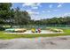 Collection of colorful kayaks and canoes stored on racks by a lush green area at 1175 San Carlos Ne Ave, St Petersburg, FL 33702