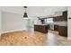 Modern open kitchen with stainless steel appliances, granite countertops, an island and stylish dark wood cabinetry at 1175 San Carlos Ne Ave, St Petersburg, FL 33702