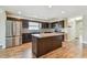 Chic kitchen featuring stainless appliances, granite countertops, tile backsplash, and dark cabinets with an island at 1175 San Carlos Ne Ave, St Petersburg, FL 33702