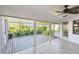 Enclosed lanai featuring tile flooring, a ceiling fan, and beautiful views of the pond and landscaping at 1175 San Carlos Ne Ave, St Petersburg, FL 33702