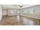 Bright living room with shuttered windows, ceiling fan, and door leading outside, with stylish wood-look flooring at 1175 San Carlos Ne Ave, St Petersburg, FL 33702