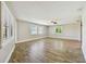 Inviting living area featuring shuttered windows, a ceiling fan, and neutral paint with wood-look flooring at 1175 San Carlos Ne Ave, St Petersburg, FL 33702