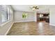 Living room with wood-look flooring, neutral walls, and bright natural light with an open concept into the kitchen at 1175 San Carlos Ne Ave, St Petersburg, FL 33702