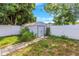 A white shed in a yard surrounded by a white fence and trees at 11809 129Th Ave, Largo, FL 33778