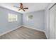 This bedroom features light gray walls, wood-look flooring, a ceiling fan, and two windows with blinds at 11809 129Th Ave, Largo, FL 33778