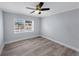This bedroom features light gray walls, wood-look flooring, a ceiling fan, and a window with blinds at 11809 129Th Ave, Largo, FL 33778