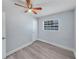 This bedroom features light gray walls, wood-look flooring, a ceiling fan, and a window with blinds at 11809 129Th Ave, Largo, FL 33778
