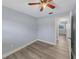 This bedroom features light gray walls, wood-look flooring, a ceiling fan, and closet with white doors at 11809 129Th Ave, Largo, FL 33778