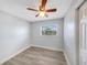 This bedroom features light gray walls, wood-look flooring, a ceiling fan, and a window with blinds at 11809 129Th Ave, Largo, FL 33778