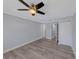 This bedroom features light gray walls, wood-look flooring, a ceiling fan, and closet with white doors at 11809 129Th Ave, Largo, FL 33778