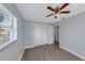 This bedroom features light gray walls, wood-look flooring, a ceiling fan, and a double closet with white doors at 11809 129Th Ave, Largo, FL 33778