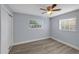 Bright bedroom with wood-look floors, ceiling fan, and two windows, offering a comfortable living space at 11809 129Th Ave, Largo, FL 33778