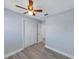 This bedroom features light gray walls, wood-look flooring, a ceiling fan, and a double closet with white doors at 11809 129Th Ave, Largo, FL 33778