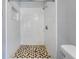Shower featuring marble-look walls, a shower head, and a patterned floor at 11809 129Th Ave, Largo, FL 33778