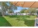 Grassy backyard with playset, mature trees, and white fencing for privacy at 11927 Steppingstone Blvd, Tampa, FL 33635