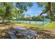 Community basketball court with green surface, benches, picnic table, and shady trees in a park-like setting at 11927 Steppingstone Blvd, Tampa, FL 33635