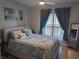 Cozy bedroom with a patterned comforter, a large window, a ceiling fan, and hardwood floors at 1216 S Missouri Ave # 223, Clearwater, FL 33756
