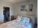 Comfortable bedroom with walk-in closet, hardwood floors, and a patterned comforter, next to a small nightstand at 1216 S Missouri Ave # 223, Clearwater, FL 33756