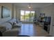 Bright living room featuring hardwood floors, comfortable sofa, large window with views, and a modern desk at 1216 S Missouri Ave # 223, Clearwater, FL 33756