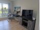 Comfortable living area featuring hardwood floors, a writing desk with decor, and TV on storage cabinet at 1216 S Missouri Ave # 223, Clearwater, FL 33756