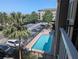 Aerial view of a refreshing community pool with lounge chairs surrounded by lush greenery at 1216 S Missouri Ave # 223, Clearwater, FL 33756