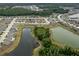 A beautiful aerial view featuring houses surrounding a pond and green spaces in the community at 12170 Gothic Rd, Spring Hill, FL 34610