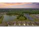 Stunning aerial view of the community with a sunset sky, showcasing homes and tranquil waterfront at 12170 Gothic Rd, Spring Hill, FL 34610