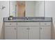 Bathroom vanity featuring granite countertops, white cabinets, and a large mirror at 12170 Gothic Rd, Spring Hill, FL 34610
