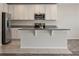 Bright kitchen featuring stainless steel appliances, white cabinets, and a large island with granite countertops at 12170 Gothic Rd, Spring Hill, FL 34610