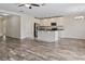 Spacious living room featuring wood-look flooring that transitions to a kitchen with white cabinets and stainless appliances at 12170 Gothic Rd, Spring Hill, FL 34610