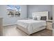 Cozy bedroom featuring wood floors, neutral paint, a comfortable bed and bright window at 12653 Palapa Loop, Spring Hill, FL 34610