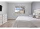 Well lit bedroom featuring wood floors, neutral paint, a comfortable bed, and large window at 12653 Palapa Loop, Spring Hill, FL 34610