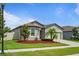 A well-maintained front yard with beautiful landscaping, lush lawn, and an inviting facade at 12653 Palapa Loop, Spring Hill, FL 34610