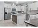Well-lit kitchen showcasing stainless steel appliances, white cabinets, granite countertops, and tile floors at 12653 Palapa Loop, Spring Hill, FL 34610
