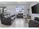 A Comfortable living room with tile floors, plush leather sofas and lots of natural light at 12653 Palapa Loop, Spring Hill, FL 34610