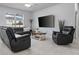 A Comfortable living room showcasing stylish furniture, tile floors, and a large flat screen TV at 12653 Palapa Loop, Spring Hill, FL 34610
