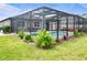 A beautiful screened-in pool area with tropical plants and furniture at 12653 Palapa Loop, Spring Hill, FL 34610