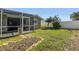 View of the home and backyard from the lanai with a well-maintained yard at 13000 90Th Ave, Seminole, FL 33776