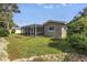 Backyard view of the property featuring a screened lanai and a well maintained yard at 13000 90Th Ave, Seminole, FL 33776