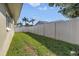 Spacious backyard featuring a white vinyl fence, green grass, and palm trees in the distance at 13000 90Th Ave, Seminole, FL 33776