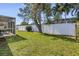 Backyard featuring a screened lanai, white fence, and green lawn at 13000 90Th Ave, Seminole, FL 33776