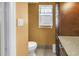 Bright bathroom with a toilet, cabinet storage, and small window at 13000 90Th Ave, Seminole, FL 33776